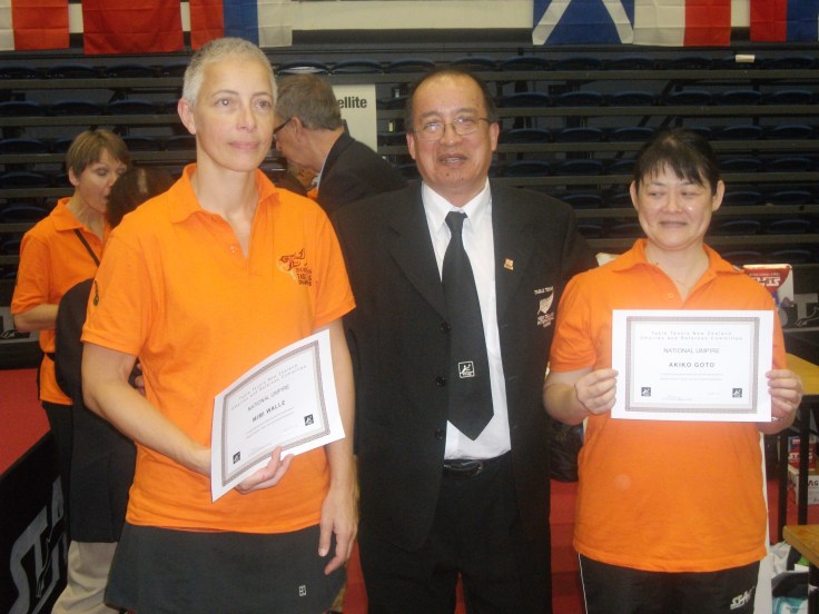 National Umpires Mimi Walle (Left) and Akiko Goto (Right) receiving their certificate from Malcolm Wong (URC).